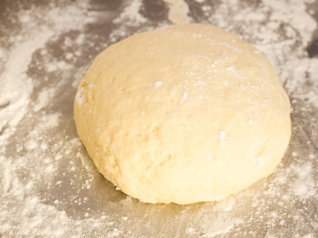 Kneaded ball of dough on a cutting board.