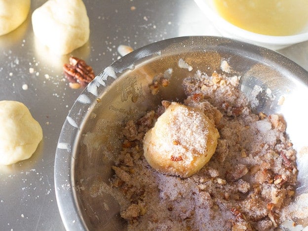 Rolling dough in cinnamon topping.