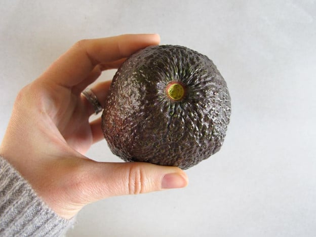 Checking an avocado for ripeness.