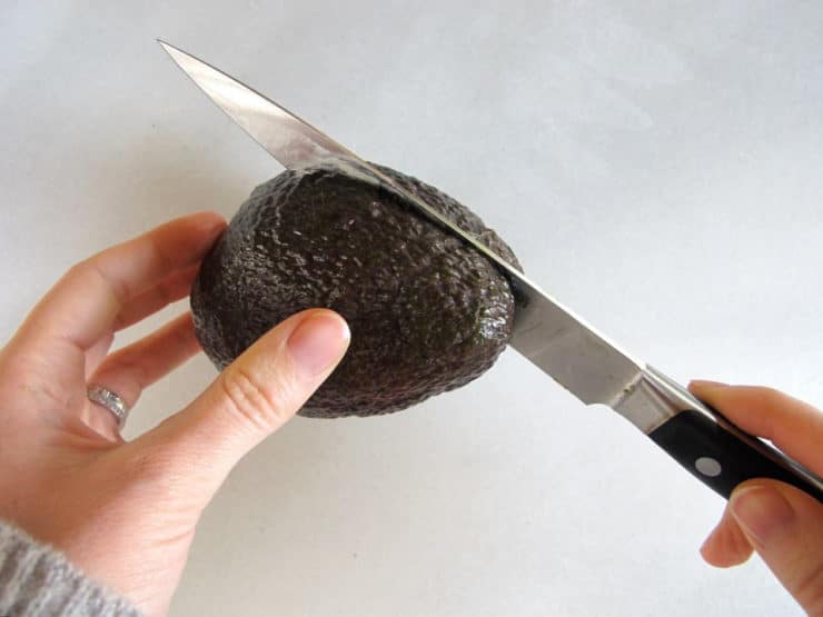 Slicing an avocado in half.