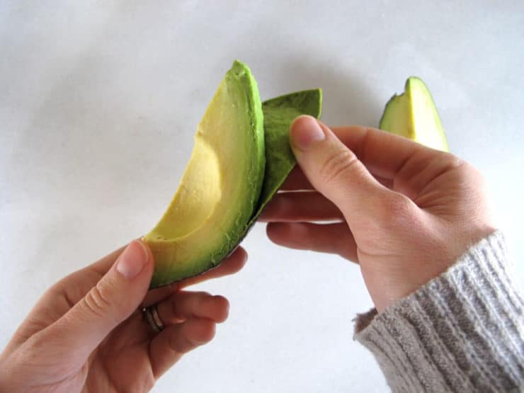 How taPulling the peel off a quarter of an avocado.o Slice an Avocado - Step-by-Step Photo Tutorial for Slicing and Peeling an Avocado