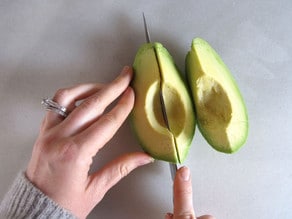 Slicing peeled avocado.