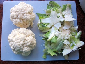 Stem and leaves removed from cauliflower heads.