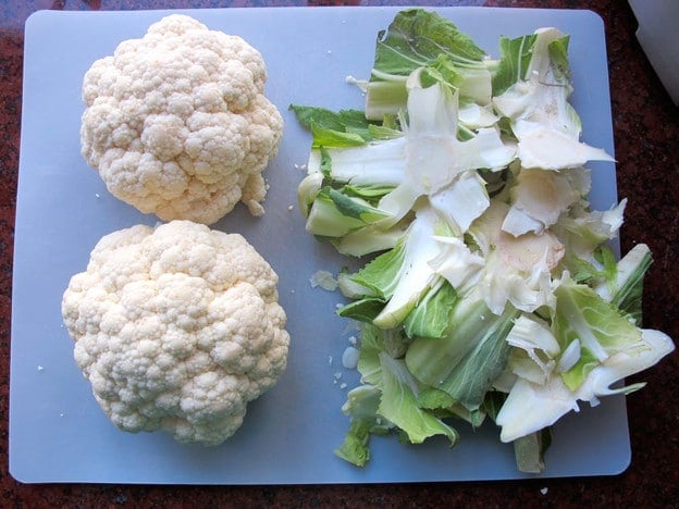 Stem and leaves removed from cauliflower heads.