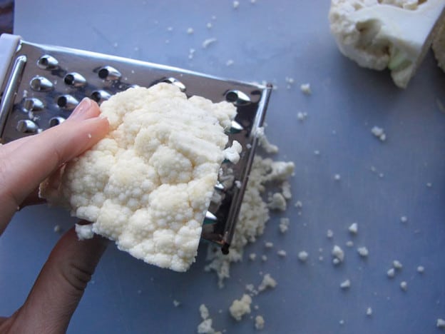 Grating a head of cauliflower.