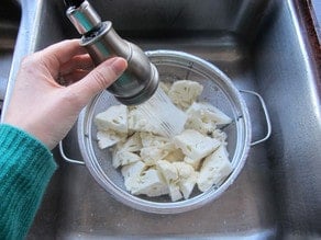 Rinsing cauliflower florets.