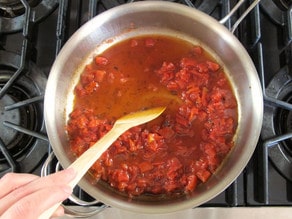 Diced tomatoes added to a saucepan.