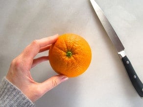 Washed orange on a cutting board.