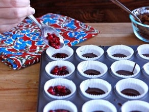 Adding pomegranate arils to muffin liners.