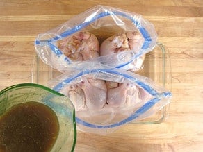 Adding marinade to Cornish hens in bags.