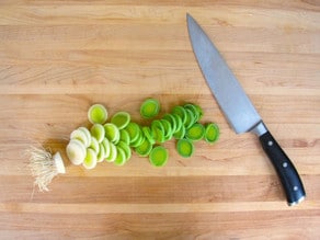 Thinly slicing leeks.