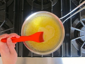 Reducing orange juice on the stove to make a sauce.