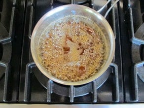 Heating maple syrup and sugar in a saucepan.
