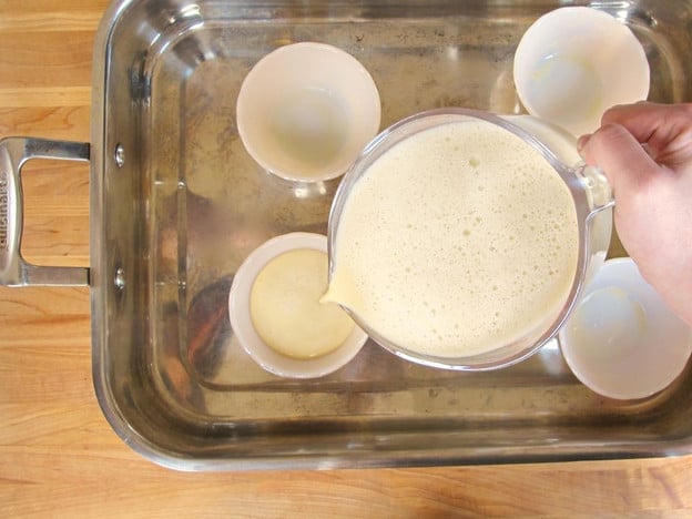 Pouring custard into ramekins.