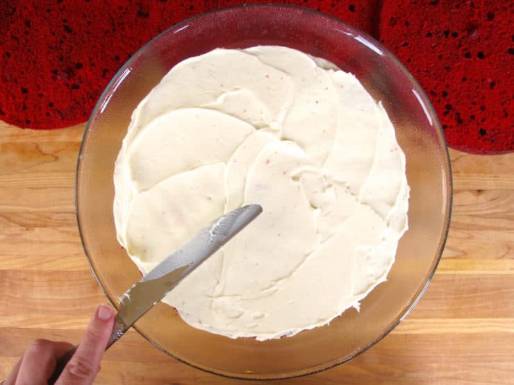 Frosting round cake layers.