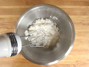 Creaming shortening and sugar with a mixer.