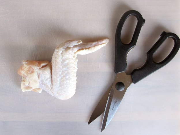 Separating the two chicken wing parts.