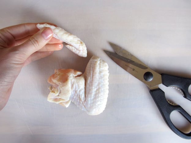 Trimming chicken wing tips.