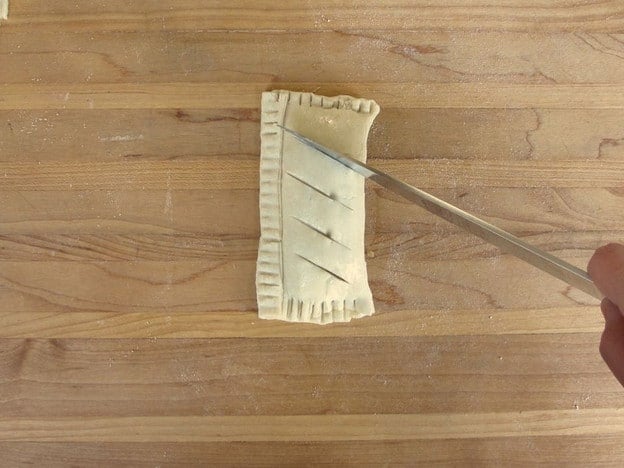 Slicing vents in puff pastry.