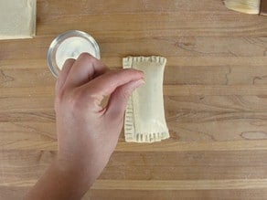 Sealing edges of pastry with a fork.