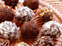 Chocolate truffles on a clear glass plate with sprinkles and coconut shavings