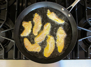 Frying catfish fingers in a skillet.