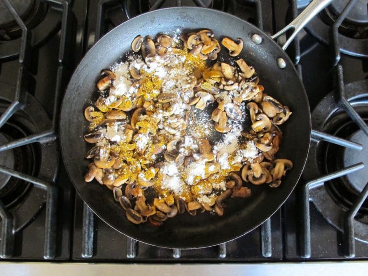 Coating sliced mushrooms with curry and flour.