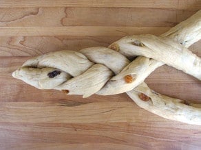 Braiding three strands of bread dough.
