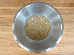 Milk, butter, and sugar added to yeast in a mixing bowl.