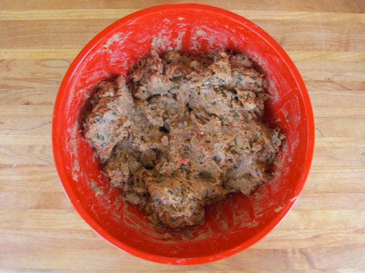 Veal with dried fruit and spices chopped up in a mixing bowl.