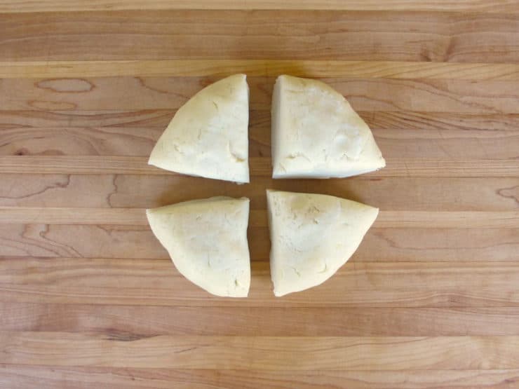 Pie crust dough divided into four equal parts.