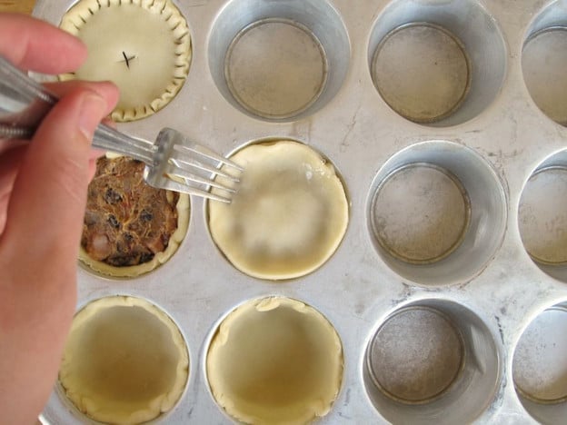 Crimping mini pies with a fork.