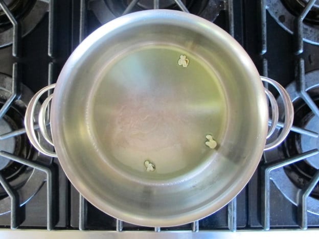 Testing a few kernels of popcorn in a pot.