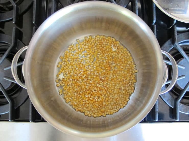 Popcorn kernels in a deep pot.