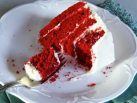 A slice of Red Velvet Cake on a plate, showcasing its rich red color and velvety texture