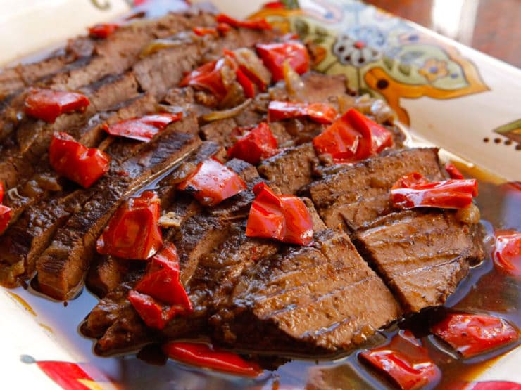 Rum and Coffee Brisket with cooked red pepper garnish on decorative serving platter.