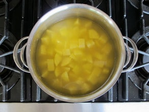 Diced potatoes boiling in broth.