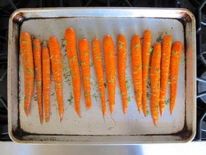 Carrots on a baking sheet with oil and dill.