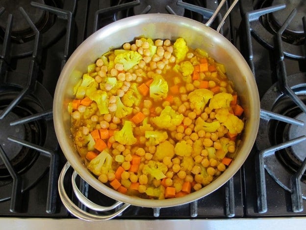 Chickpeas and seasoning added to onion in skillet.