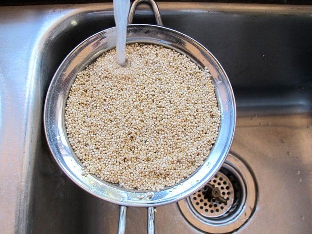 Rinsing quinoa in a strainer.