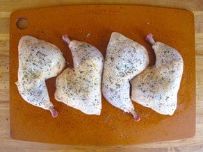 Seasoned chicken parts on a cutting board.