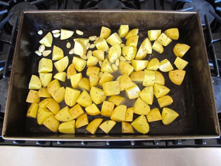Diced potatoes spread into a hot roasting dish.