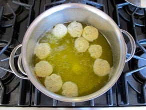 Matzo balls cooking in broth.