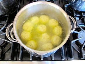 Cooked matzo balls in chicken stock.