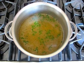 Chopped dill added to chicken stock.