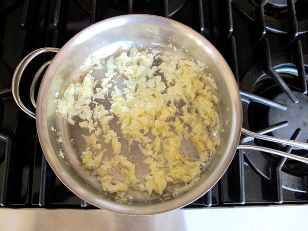 Sautéing sliced onion in a sauté pan.