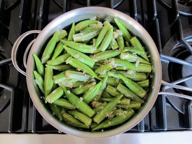 Okra added to sauté pan with onions.