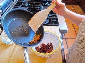 Removing toasted peppers from a skillet.
