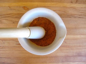 Grinding spices with a mortar and pestle.