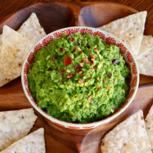 Overhead shot of Spring Pea Guacamole with nachos on sides